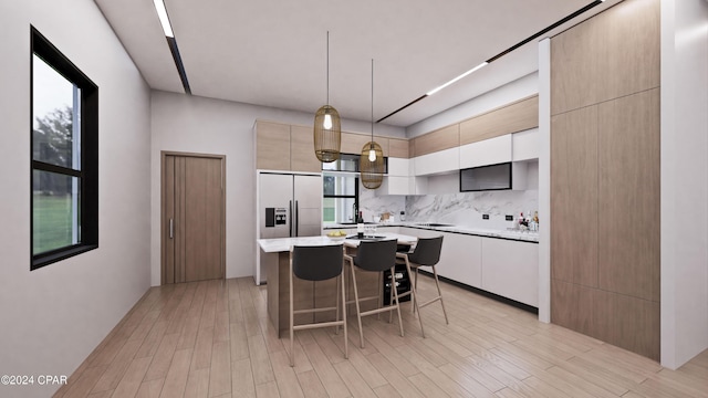 kitchen featuring a kitchen bar, backsplash, pendant lighting, a center island, and light hardwood / wood-style floors