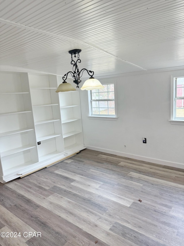 unfurnished dining area featuring plenty of natural light, light wood-type flooring, and built in shelves