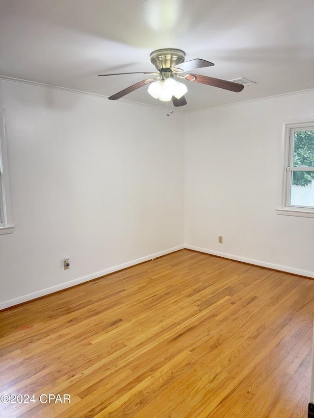 empty room with ceiling fan, ornamental molding, and light wood-type flooring