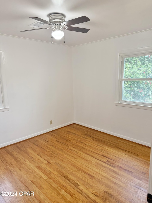 spare room featuring light hardwood / wood-style flooring, ceiling fan, and ornamental molding