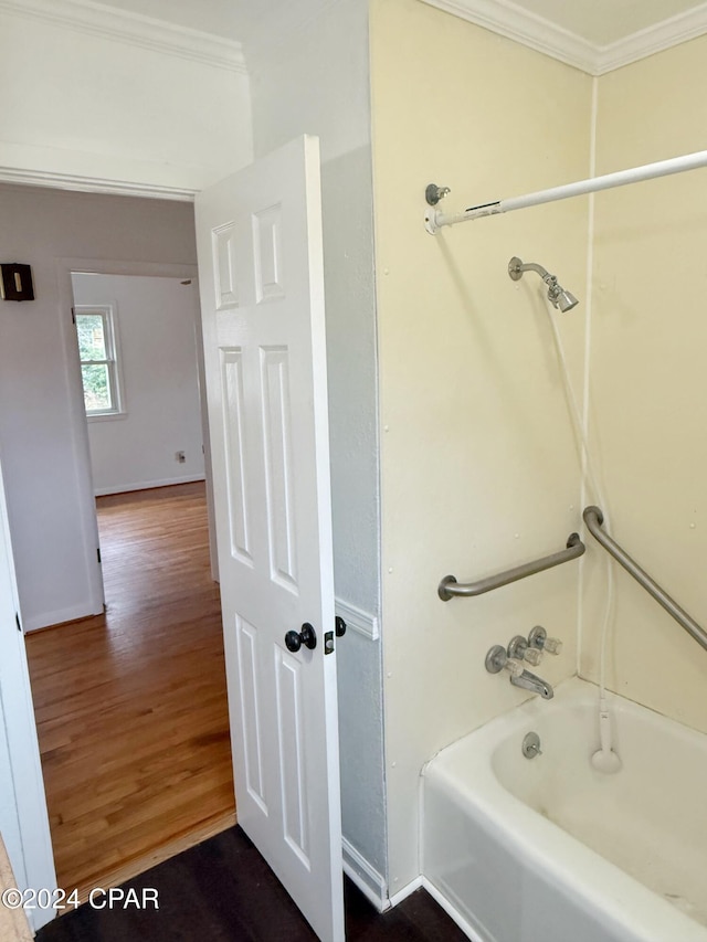 bathroom with shower / bath combination, wood-type flooring, and crown molding