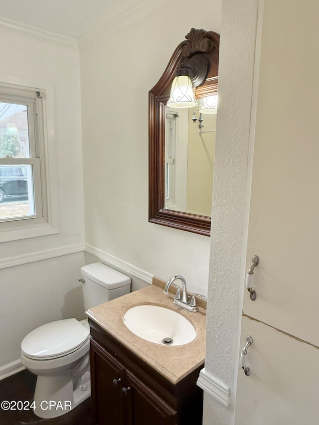 bathroom with vanity, toilet, and ornamental molding