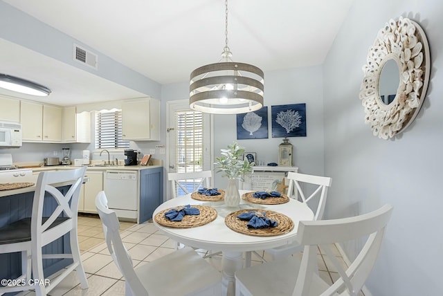 dining area with visible vents, a notable chandelier, and light tile patterned flooring