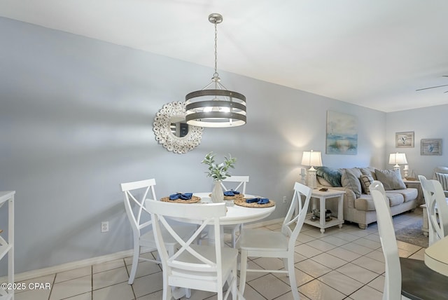 dining room featuring tile patterned flooring, baseboards, and a notable chandelier