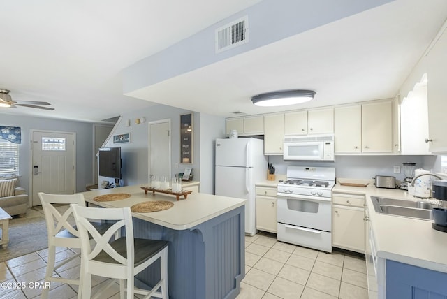 kitchen with white appliances, visible vents, open floor plan, light countertops, and a sink