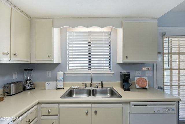 kitchen featuring light countertops, white dishwasher, and a sink