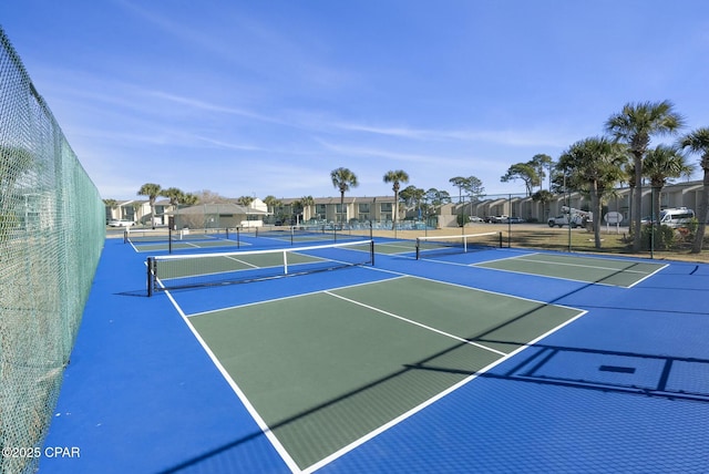 view of sport court with a residential view and fence