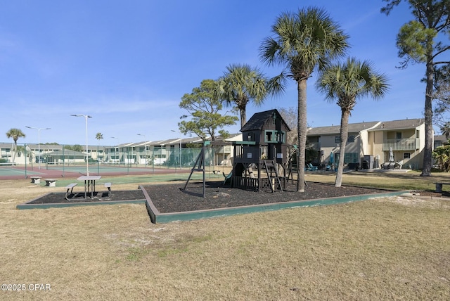 communal playground featuring a residential view, a tennis court, and fence