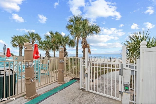 view of gate with a water view and fence