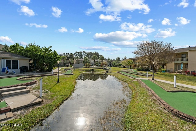 view of home's community with a residential view, a water view, and a lawn