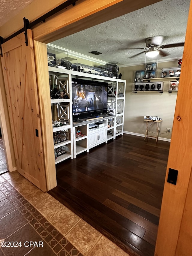 bar with a textured ceiling, ceiling fan, and a barn door