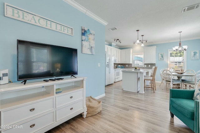 313 Laureno Pl, Panama City Beach, FL 32413 - living room featuring ornamental molding, a chandelier, and light hardwood / wood-style floors