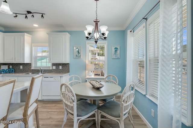 313 Laureno Pl, Panama City Beach, FL 32413 - dining area with a notable chandelier, ornamental molding, sink, and light wood-type flooring