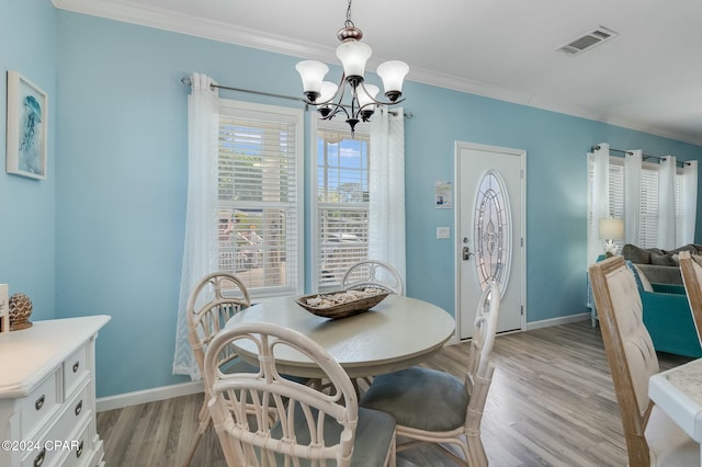 313 Laureno Pl, Panama City Beach, FL 32413 - dining space featuring an inviting chandelier, ornamental molding, and light wood-type flooring