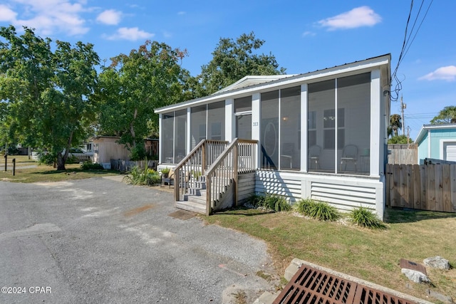 manufactured / mobile home featuring a front lawn and a sunroom