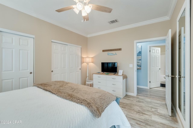 313 Laureno Pl, Panama City Beach, FL 32413 - bedroom with multiple closets, ceiling fan, ornamental molding, and light hardwood / wood-style floors