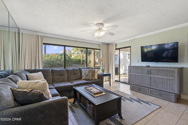 living room featuring a textured ceiling, ceiling fan, light tile patterned floors, and ornamental molding