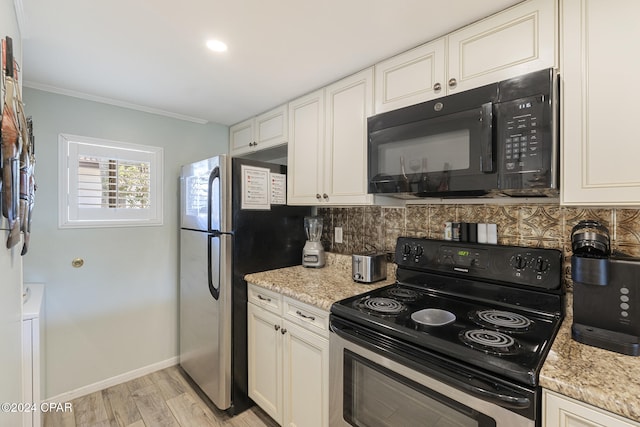 kitchen featuring decorative backsplash, white cabinetry, light stone counters, and black appliances