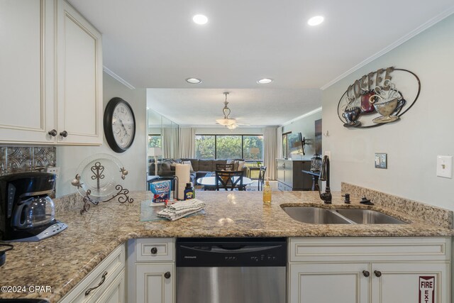 kitchen with sink, light stone counters, stainless steel dishwasher, white cabinets, and ornamental molding