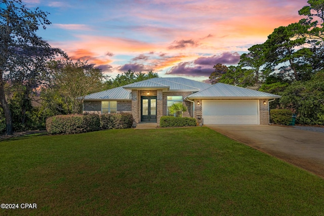 view of front facade with a yard and a garage