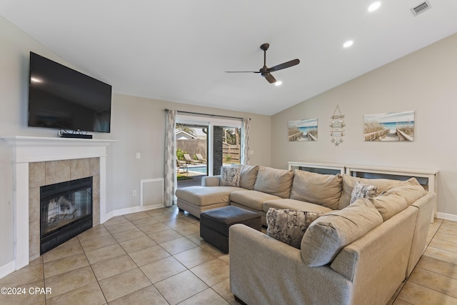 tiled living room featuring ceiling fan, a fireplace, and vaulted ceiling