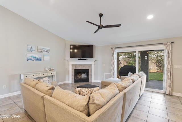 tiled living room featuring a tile fireplace, vaulted ceiling, and ceiling fan