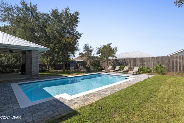 view of swimming pool with a yard, a patio, and ceiling fan