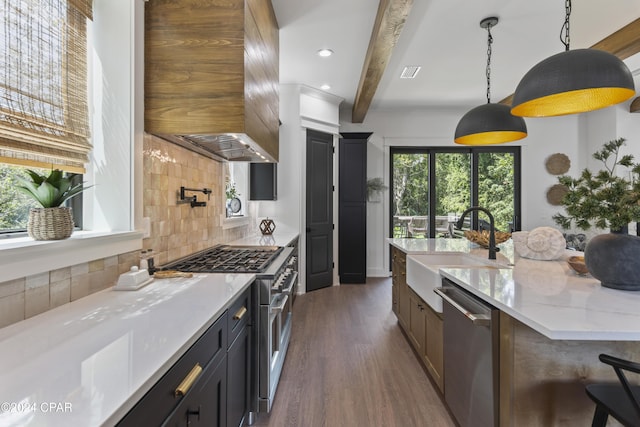 kitchen with beam ceiling, sink, backsplash, pendant lighting, and appliances with stainless steel finishes