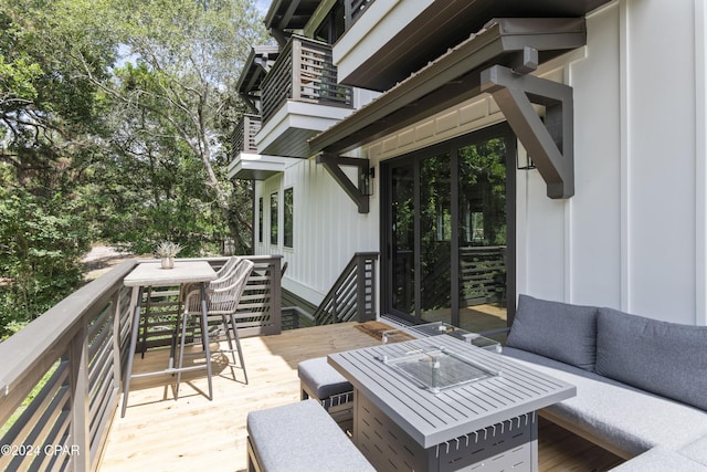 wooden terrace featuring an outdoor living space with a fire pit