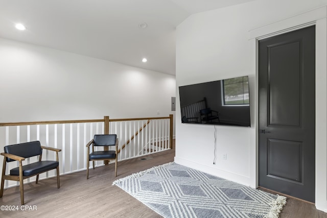 living area with wood-type flooring and vaulted ceiling