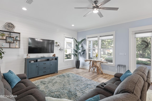 living room featuring ceiling fan, ornamental molding, and light hardwood / wood-style flooring