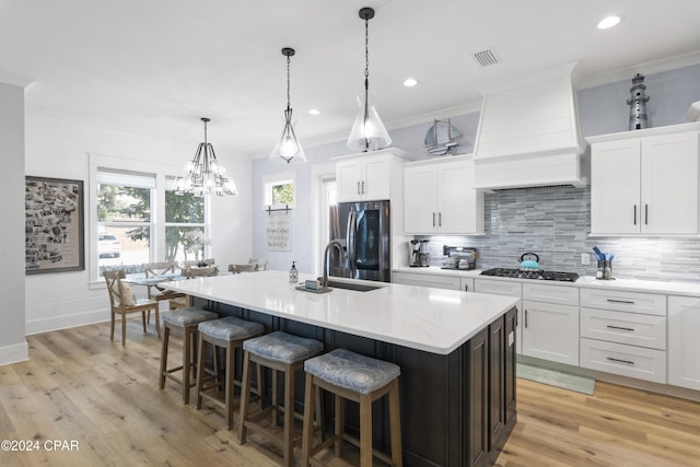 kitchen featuring white cabinetry, custom range hood, and stainless steel refrigerator with ice dispenser