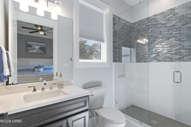 bathroom featuring walk in shower, vanity, toilet, and ceiling fan