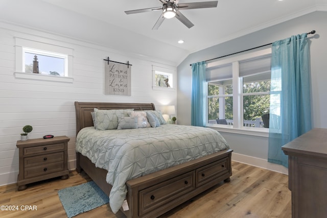 bedroom featuring ceiling fan, light hardwood / wood-style flooring, lofted ceiling, and ornamental molding