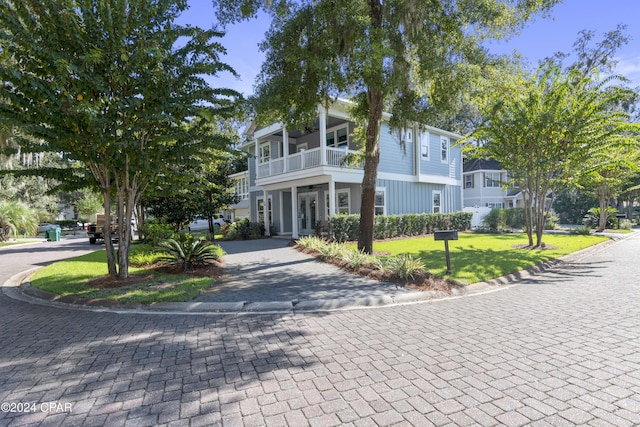 view of front facade featuring a front yard and a balcony