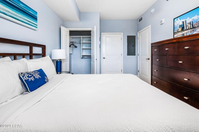 bedroom featuring electric panel and a closet