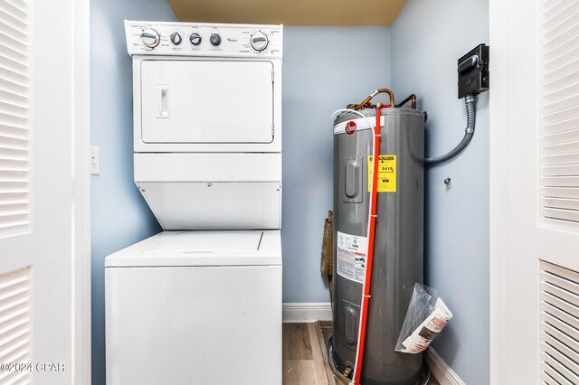 clothes washing area featuring water heater, stacked washer and clothes dryer, and light wood-type flooring