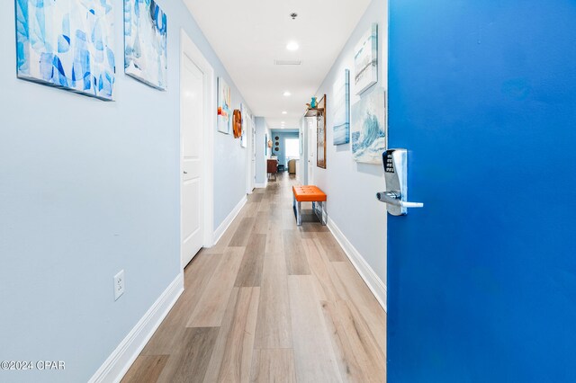 hallway with light hardwood / wood-style floors