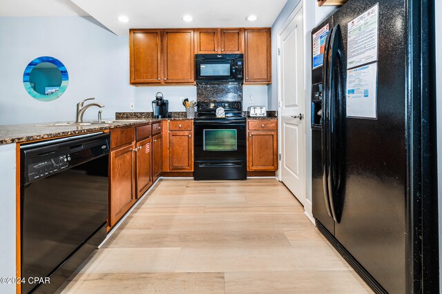 kitchen with light wood-type flooring, sink, and black appliances