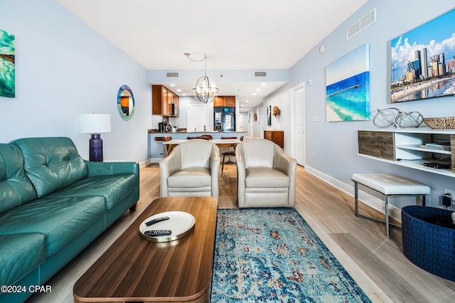 living room with light hardwood / wood-style floors and an inviting chandelier