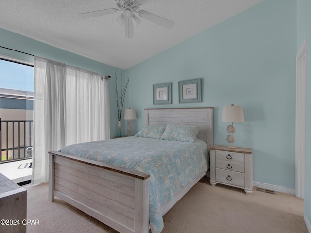 bedroom with lofted ceiling, ceiling fan, light carpet, and a textured ceiling