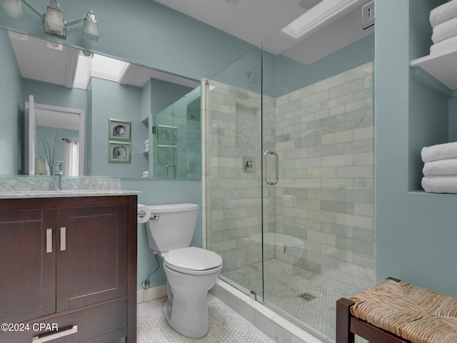 bathroom featuring a skylight, walk in shower, tile patterned flooring, toilet, and vanity