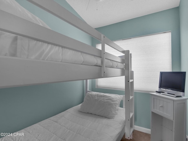 bedroom featuring ceiling fan and a textured ceiling