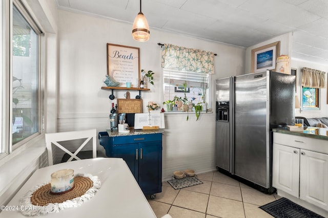 kitchen with blue cabinetry, light tile patterned floors, white cabinets, stainless steel fridge with ice dispenser, and hanging light fixtures