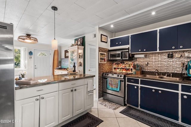 kitchen featuring pendant lighting, backsplash, blue cabinets, appliances with stainless steel finishes, and white cabinetry