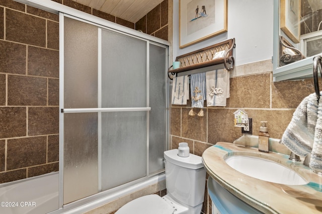 bathroom featuring vanity, a shower with shower door, tile walls, and toilet