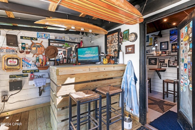 bar featuring wooden walls and hardwood / wood-style floors