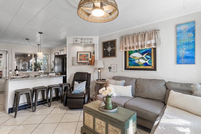 living room with ceiling fan, light tile patterned floors, and ornamental molding