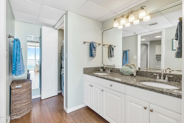 bathroom with hardwood / wood-style floors, a paneled ceiling, and vanity