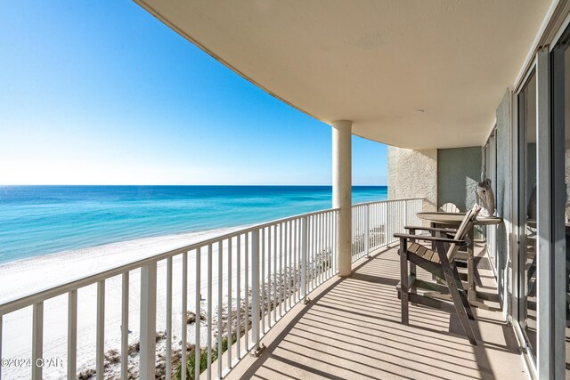 balcony featuring a water view and a view of the beach